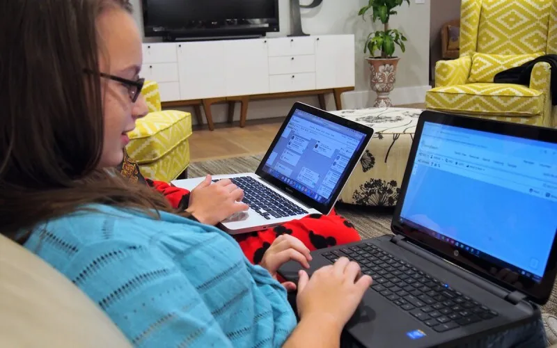 a girl works on her family history at home. 