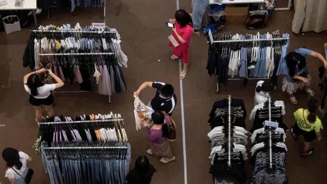 People shop for clothes at a mall in Shenzhen, in China's southern Guangdong province on May 21, 2020.